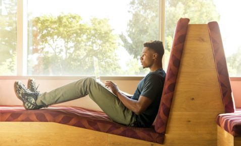 man sat on a cushoned chair working